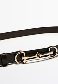 Ceinture en cuir noir avec une boucle en métal doré au design classique de mors de cheval, texture lisse et finition minimaliste.
