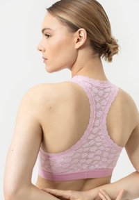 Soutien-gorge de sport en dentelle rose avec un dos nageur, doté d'une bande élastique douce et d'une délicate texture en dentelle au dos.