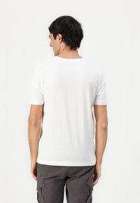Hvid t-shirt med korte ærmer og rund halsudskæring. Blød tekstur, afslappet pasform og et enkelt design uden synlige logoer eller mønstre.
