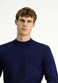 Granatowy sweter dziewiarski z prążkowanym kołnierzykiem, dopasowanymi długimi rękawami i gładką fakturą, prezentujący prosty i elegancki design.