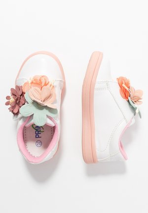 Weiße Sneakers mit einer pinken Sohle, die an der Seite mit bunten Stoffblumen in Pink, Pfirsich und Grün verziert sind. Glattes, synthetisches Material.