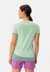 Mint green short-sleeve top with a rounded neckline and light blue accents. The fabric appears lightweight and slightly textured.