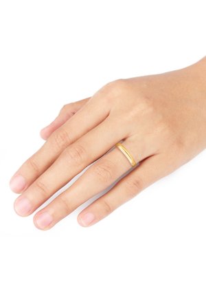 Goldener metal Ring mit einem glatten, abgerundeten Band. Auf einer menschlichen Hand mit natürlichen, unpolierten Nägeln vor einem weißen Hintergrund getragen.