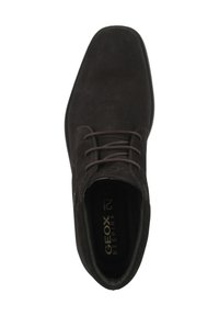 Zapato de ante negro con punta redondeada, cinco ojetes y cordones planos. El interior cuenta con una plantilla de marca, con un diseño suave y minimalista.