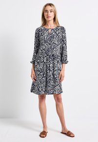 Kniekurzes Kleid im marineblauen und cremefarbenen Zebramuster, mit einem runden Ausschnitt mit Schlüsselanhausschnitt und fließenden 3/4-Ärmeln.