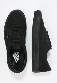 Schwarze Canvas-Sneaker mit niedrigem Schnitt, flacher Gummisohle, runder Zehenpartie und Schnürung mit sechs Ösen. Mit Vans-Logo auf der Zunge.