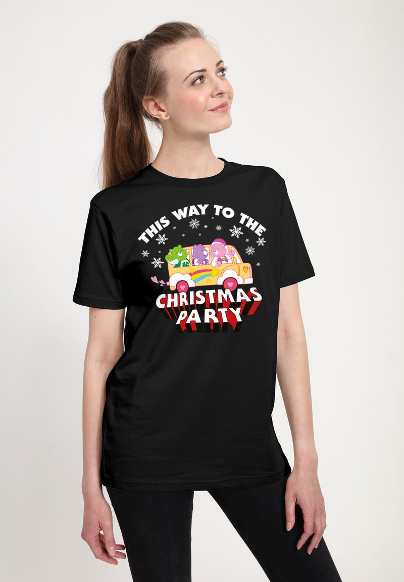 Sort kortærmet t-shirt med en farverig grafik af tegneserie-køretøjer, tekst der står "DENNE VEJ TIL JULEFESTEN," og snefnug-akcenter.