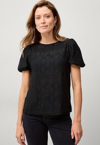 Schwarzes Spitzentop mit kurzen Puffärmeln, das ein strukturiertes geometrisches Muster aufweist, einen runden Ausschnitt hat und eine leicht lockere Passform bietet.