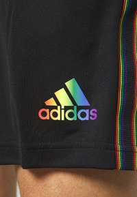 Zwarte sportshorts met multicolore strepen aan de zijkanten en een regenbooggradatie Adidas-logo op de onderste linkerpijpen.
