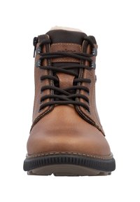 Bottes chelsea en cuir marron avec un design à lacets noirs, semelle en caoutchouc et accents cousus. Présente une fermeture éclair sur le côté. Doublure douce visible.