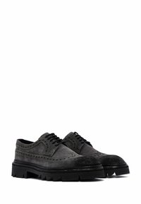 Chaussures en suède noir à lacets avec des détails brogués, finition texturée et semelle en caoutchouc robuste. Conçues avec un bout arrondi et une semelle épaisse.