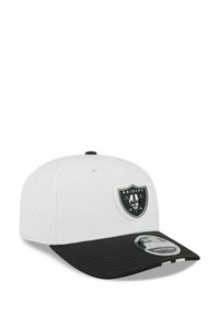 White and black baseball cap with Raiders logo patch on front and "Stretch-Snap" sticker on black curved brim.