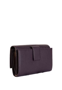 Fioletowy skórzany portfel o teksturowanym wykończeniu, z zapięciem na klapkę i wieloma przegrodami na karty i gotówkę. Smukły prostokątny kształt.