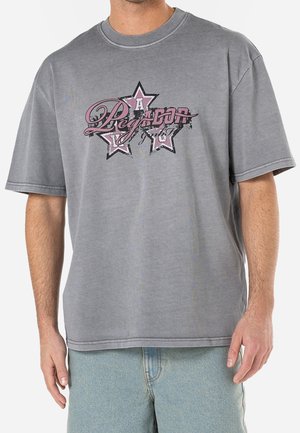 Gray oversized t-shirt featuring a central graphic design with stars and text in pink and black. Made from a soft, textured cotton blend.