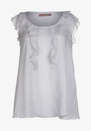 White sleeveless blouse made of smooth fabric, featuring ruffled accents along the neckline and shoulders. Soft drape and slight asymmetrical hem.