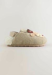 Beige Filzschuh mit einem strukturierten cremefarbenen Kunstfellfutter, das ein gesticktes Tierdesign und einen Klettverschluss an der Seite aufweist. Gummisohle.