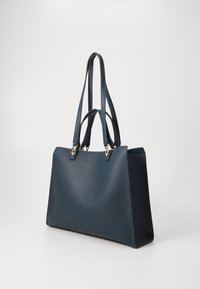 Temno modra usnjena torba za na rame z teksturirano površino, opremljena z dvema dolgima ročajema in zlatimi okrasnimi elementi. Pravokotne oblike, odprta zgornja stran.