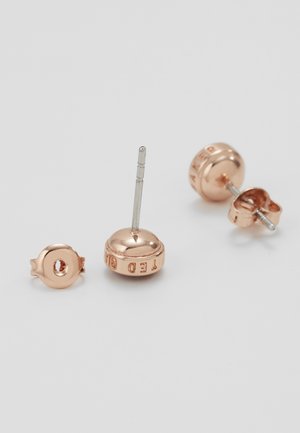 Boucles d’oreilles clous en or rose avec tiges en argent et fermoirs papillon, une boucle désassemblée montrant la tige et le fermoir séparément.