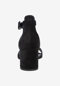Černé semišové sandály na blokovém podpatku s nastavitelným páskem kolem kotníku, otevřenou špičkou a texturovaným povrchem. Jednoduchý a moderní tvar.