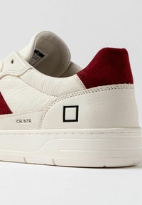 Sneaker in pelle bianca con accenti in suede rossa, dotato di un logo quadrato sul lato e di una suola bianca texturizzata. Punta arrotondata e colletto imbottito.