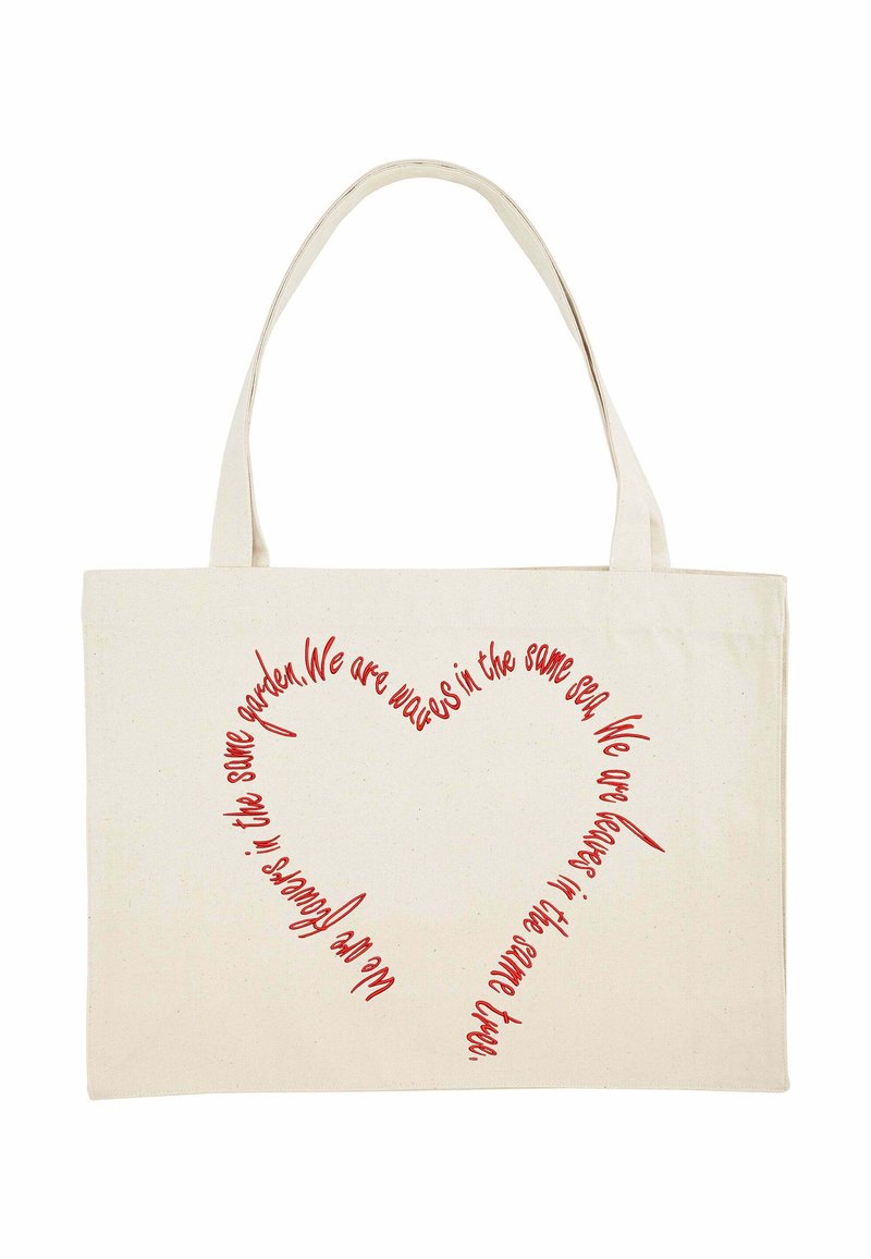 Borsa tote in tela con manici lunghi, di colore beige, con testo rosso che forma una forma di cuore accompagnata da una citazione sull'unità e la natura.