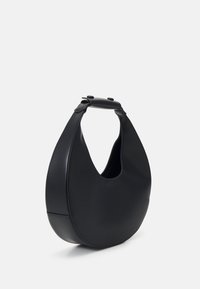 Sac à main en cuir noir de forme arrondie avec une poignée courte, debout sur un fond blanc.