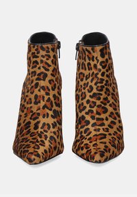 Botas de tobillo de estampado de leopardo con punta afilada, hechas de un material texturizado suave, con cremallera lateral y tacón de cuña para mayor altura.