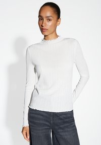 Weißes, geripptes Langarmoberteil mit hohem, gerafftem Kragen und taillierter Silhouette. Weicher Stoff, leichter Stretch und dezenter Glanz.