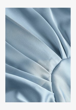 Tessuto azzurro chiaro con una texture liscia, caratterizzato da sezioni plissettate che creano un design fluido e un dettaglio centrale arricciato.