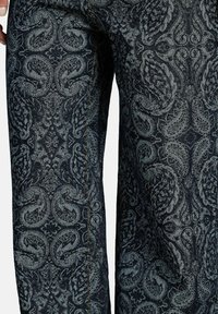 Donkerdenim jeans met een paisleypatroon in tinten van blauw en grijs, met contrasterende stiksels langs de naden.