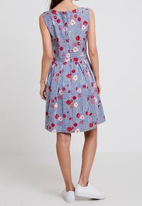 Vestido de estampado floral en rayas azules y blancas, diseño sin mangas con corsé ajustado y falda acampanada, con botones a lo largo de la espalda.