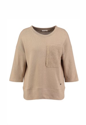 Suéter beige de corte relajado, con mangas cortas, un bolsillo de parche texturizado y una suave tela de punto. Presenta un escote redondeado y un diseño minimalista.