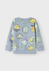 Svetlo modra majica s kapuco, ki prikazuje različne liki in logotipe Pokémon. Okrugli izrez, rebrasti manšeti in teksturirana tkanina s igrivim potiskom.