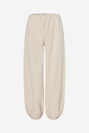 Pantalon beige coupe ample avec taille élastique et ourlets élastiqués, conçu pour un usage décontracté.