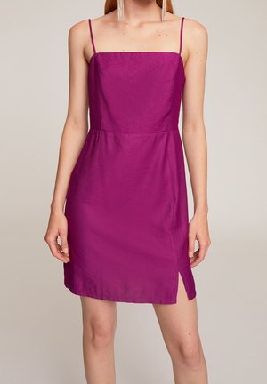 Robe sans manches fuchsia avec un décolleté carré, forme A, fente latérale et tissu texturé. Les accessoires comprennent de longues boucles d'oreilles transparentes.