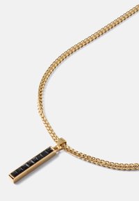 Colar de corrente em tom de ouro com um pendente retangular que apresenta pedras inlaid pretas e uma superfície polida, exibindo um design geométrico elegante.