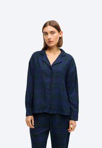 Pajama zestaw w kratkę w kolorze granatowym i zielonym, z guzikiem, kołnierzykiem i długimi rękawami, wykonany z miękkiego materiału o luźnym kroju.