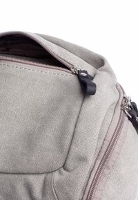 Zaino in tela grigio chiaro con superficie texturizzata, dotato di apertura superiore con zip e di una cerniera di contrasto scura.