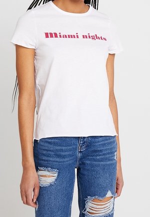 Valkoinen puuvillainen t-paita, jossa on tyylitelty "Miami nights" -teksti vaaleanpunaisella. Paidassa on lyhyet hihat ja rento istuvuus, yhdistettynä kulutettuihin farkkuihin.