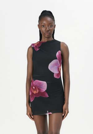 Zwarte mouwloze jurk met grote paarse orchideeënprints, getailleerd ontwerp, zachte textuur en een subtiel asymmetrisch halsdetail.