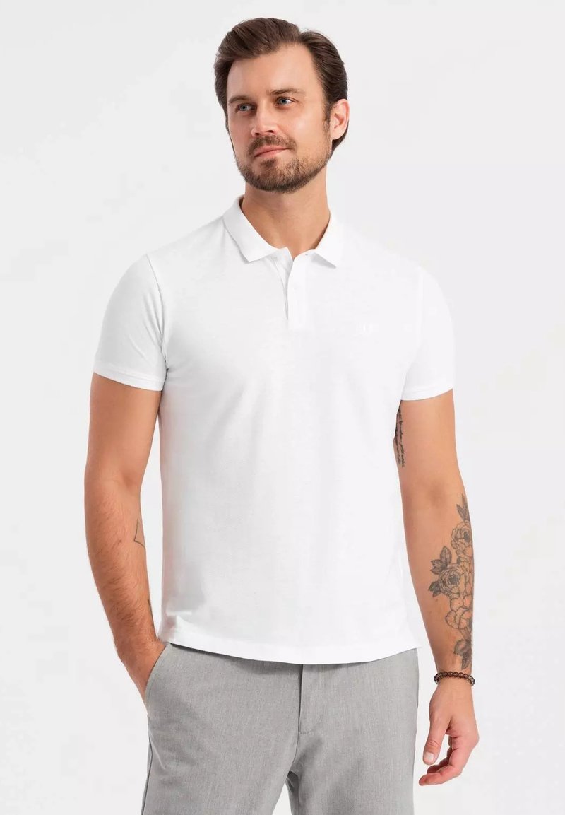 Bílá polo košile s krátkým rukávem a límečkem, vyrobená z texturované látky. Má slim fit střih a decentní logo značky na hrudi.