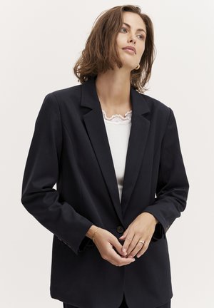 Dark navy blazer with a notched lapel, single button closure, and long sleeves. Features subtle stitching detail and relaxed fit.