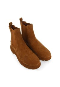 Bottines en daim marron avec des panneaux latéraux en élastique, une languette et une semelle en caoutchouc texturée épaisse. Finition lisse et douce.