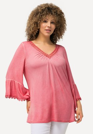 Top rosa a scollo a V con dettagli arricciati, bordi in pizzo sulle maniche a campana e una vestibilità comoda. Tessuto morbido, con leggera variazione di colore.