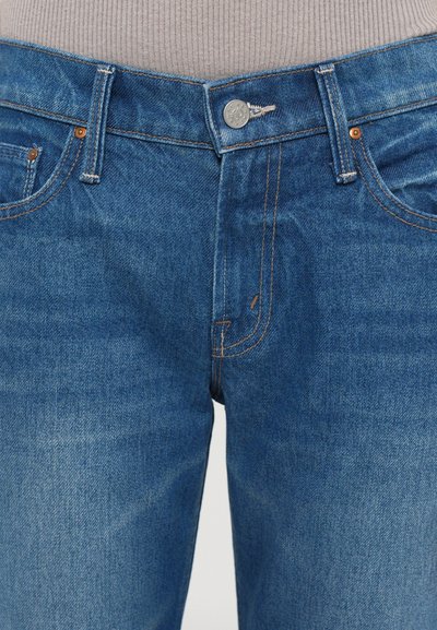 Blauwe spijkerbroeken van denim met een middelhoge taille, voorzien van oranje stiksels, vijf zakken en een zilveren knoopsluiting.