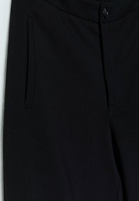 Zwarte broek van gladde stof met een knoopsluiting en een zijzak. Het ontwerp is gesneden met strakke lijnen en een elegante uitstraling.