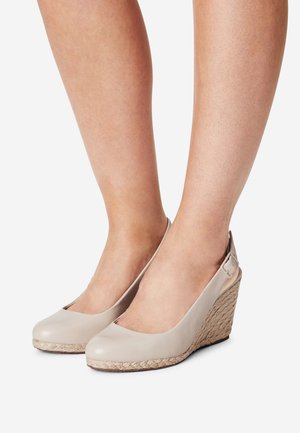 Talons compensés beiges avec une tige en cuir lisse et un détail en jute tressé sur le talon. Dos ouvert avec une sangle ajustable. Design à bout arrondi.
