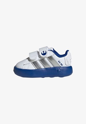 White sneaker with silver stripes and blue accents. Features a Velcro strap and a rounded blue sole, with an R2-D2 design detail.