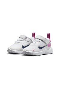 Baskets Nike présentant une tige en maille blanche, un logo bleu marine et des accents roses. Équipées d'une sangle Velcro sécurisée et d'une semelle en caoutchouc texturée.
