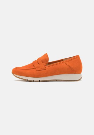 Mocassin en daim orange vif avec semelle blanche, design sans lacets, petit talon compensé, et bride décorative sur le devant, vue latérale.